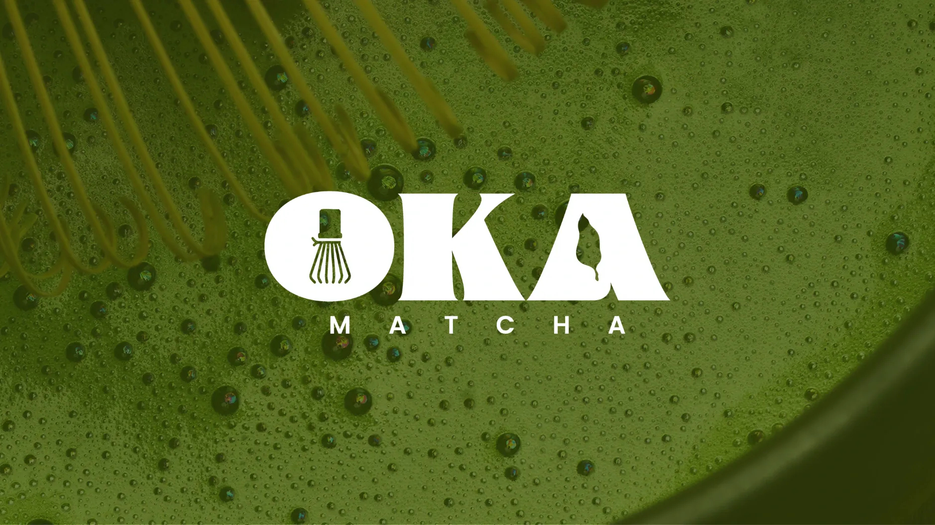 Le logotype Oka Matcha en blanc, le fouet à matcha glissé dans le O, sur un gros plan de thé vert fouetté et mousseux.